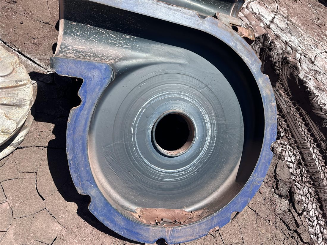 Inspection photo of a slurry-pump cover plate liner showing abrasive wear through to bare metal